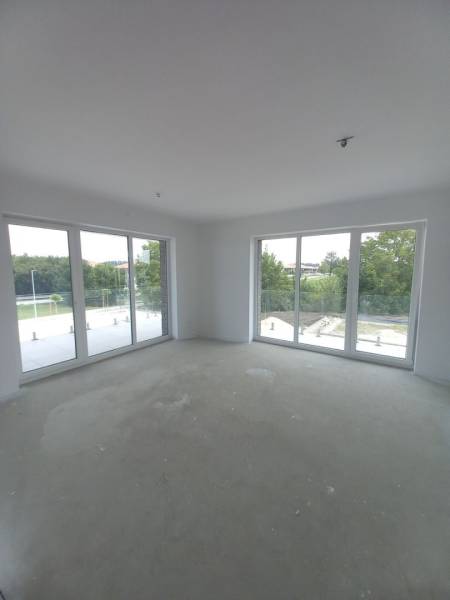 Large windows and natural light in a 2-room apartment, offering a view of greenery.
