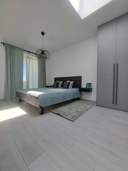 Bedroom in a 2-room apartment with wood-patterned flooring and sliding doors.