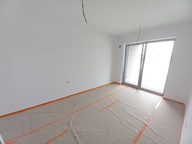 Commercial space with a large window, white paint, and a wooden decor floor covered with foil.