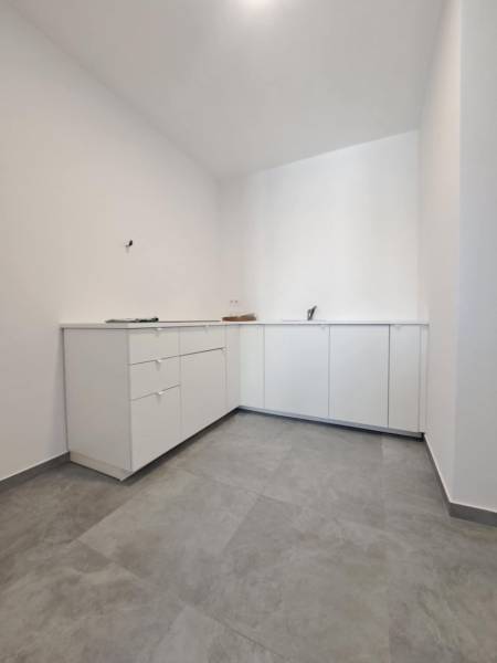 White cabinets in commercial spaces with gray tiles.