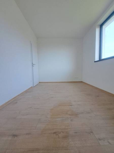Interior of a family house with a bright room, wooden decor flooring, large window.