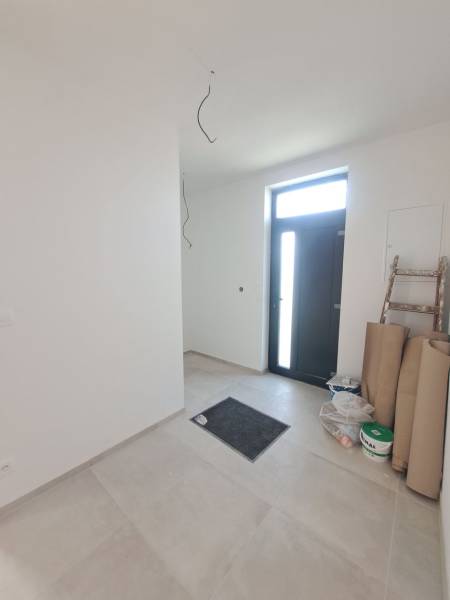 The entrance hall of the family house with tiles, next to the door is a step and material.
