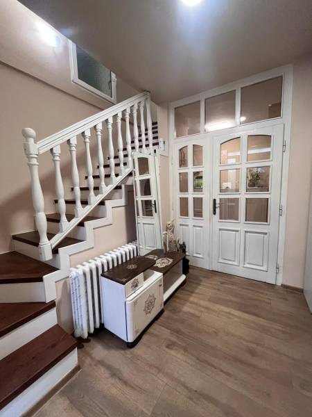 Hallway of a family house with wooden decor flooring and staircase.