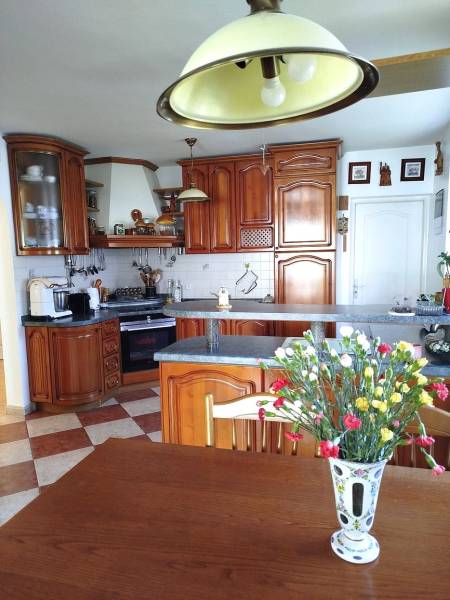 A kitchen in a family house with wooden cabinets and floral decorations.