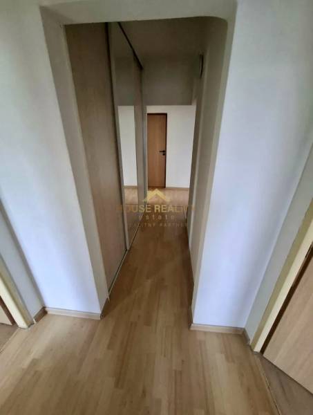 Hallway in a 4-room apartment with a wooden decor floor and a built-in wardrobe.