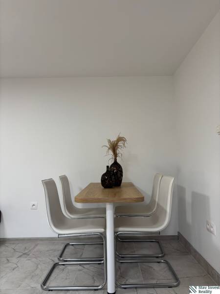 A dining room by itself with a table with a wooden decor and four chairs in a family house.