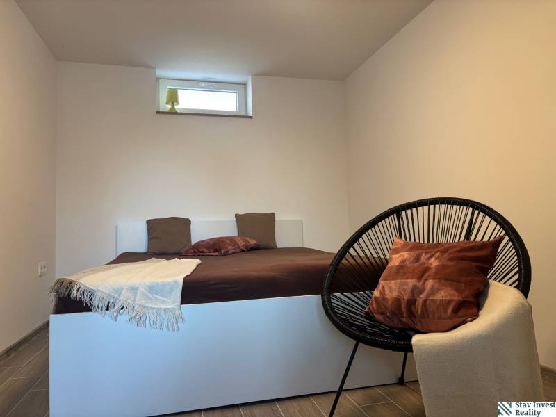 Bedroom in a family house with a simple bed and a comfortable armchair.