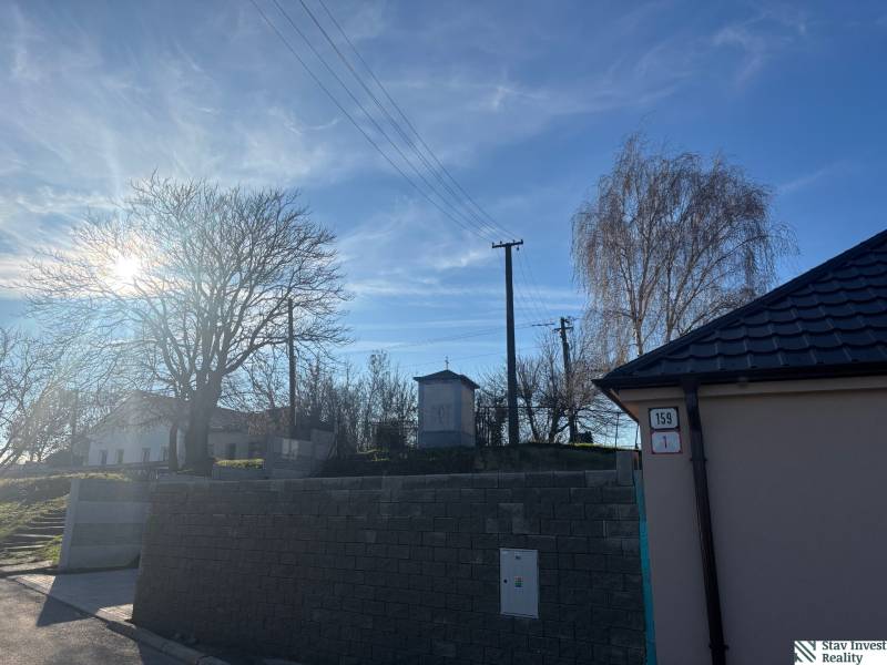 Sunny view of a family house in Blatné with a view of trees and power lines.