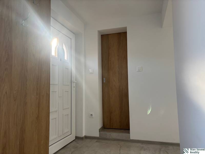 Interior of a family house with white doors and a floor with a wooden decor.