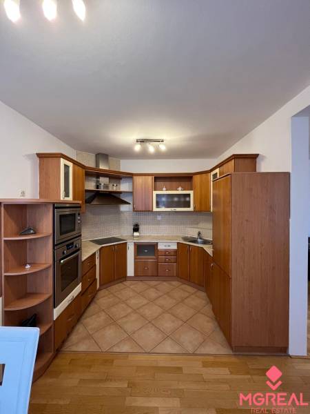 A kitchen with a corner unit and a floor with a wooden decor in a 3-room apartment.