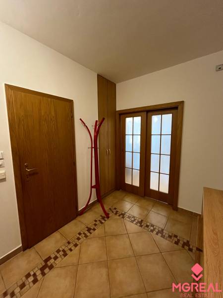 Hallway of a 3-room apartment with tiles and wooden doors.