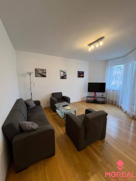 Living room in a 3-room apartment with comfortable seating and a wooden decor floor.