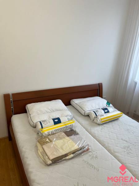 Bedroom with a double bed, wooden decor flooring, 3-room apartment.