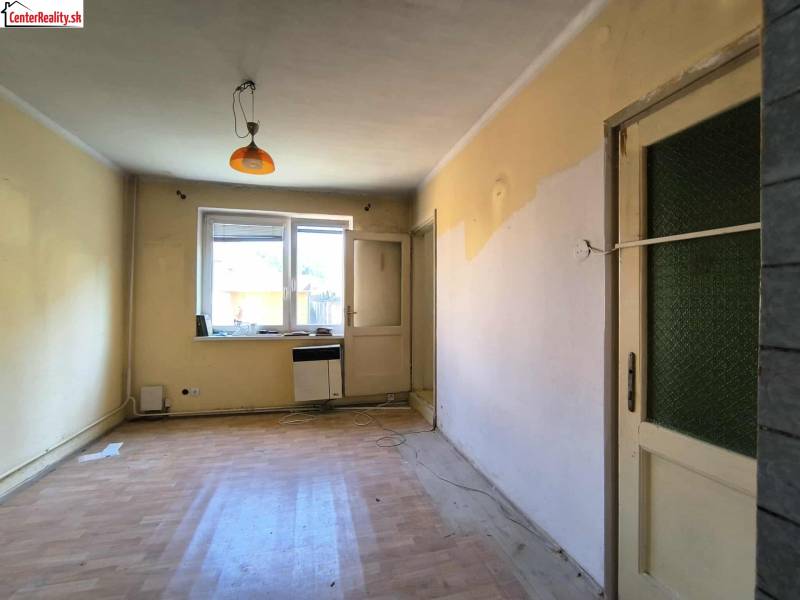 A room in a family house with a window, doors, and a floor.