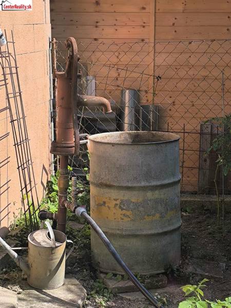 A water pump with a metal barrel in the garden of a family house in Partizánske.
