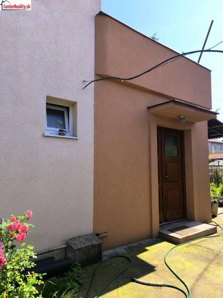 A family house in Partizánske with colored plaster and a garden.