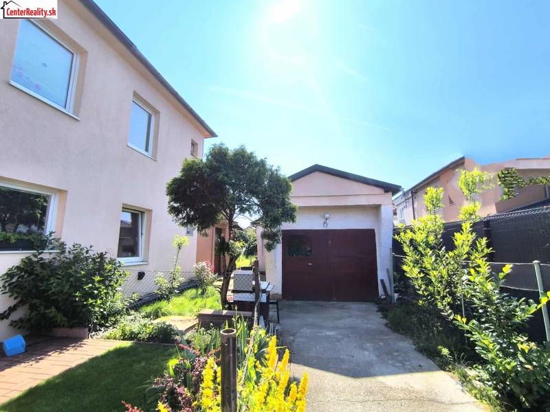 A family house in Partizánske with a landscaped garden and a garage on a quiet street.