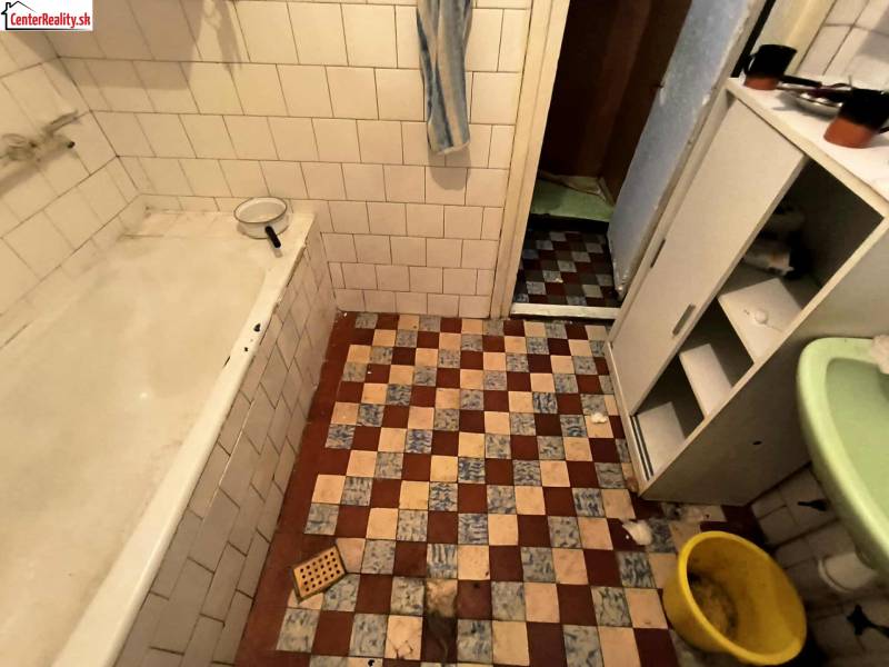 A bathroom in a family house with retro tiles and a bathtub.