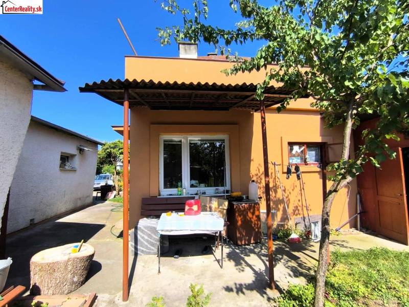 A family house in Partizánske with a terrace and a tree in the yard.