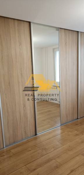 Built-in wardrobe with mirror and floor with wood decor in a 2-room apartment.