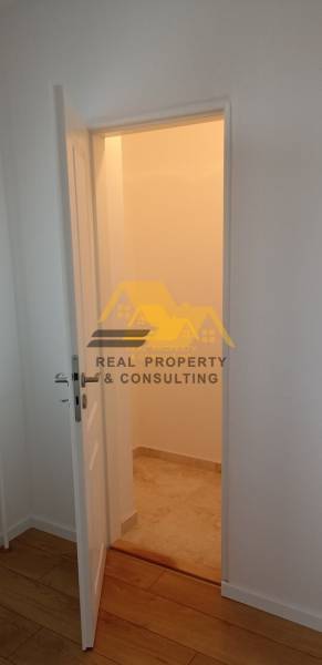 Interior of a 2-room apartment with open doors and a wooden decor floor.