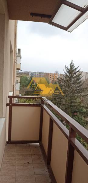A balcony in a 2-room apartment with a view of greenery and rooftops in Nové Zámky.