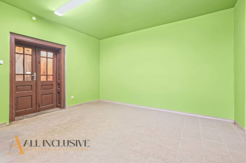 Green room with light walls, floor with wood decor, door in a family house.