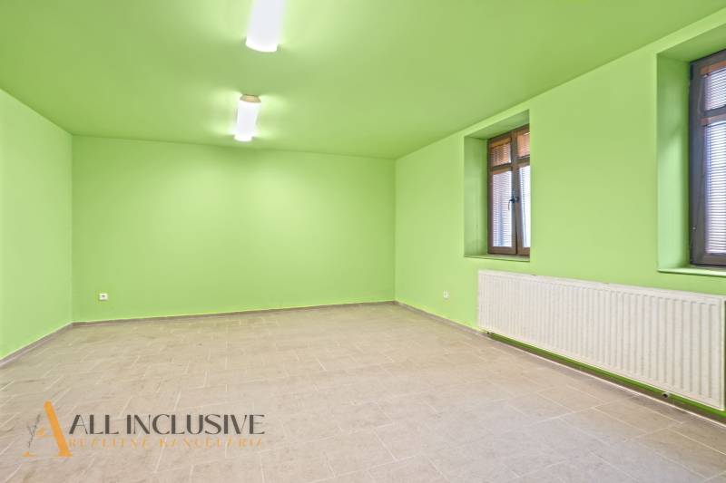 A spacious room in a family house with green walls and tiles.