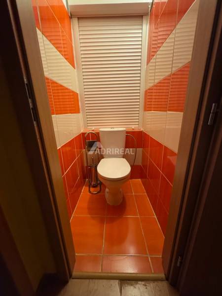 A bathroom with red and white tiles in a studio apartment.