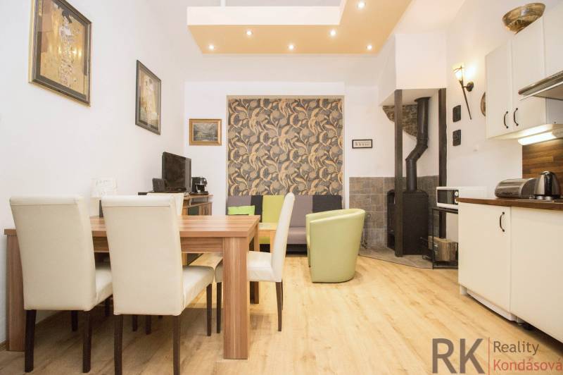 Dining area in a 2-room apartment with a wood-patterned floor and a fireplace.
