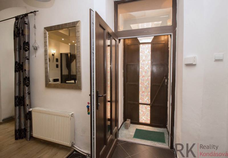 Entrance hallway with wooden doors, a mirror, and curtains in a 2-room apartment.