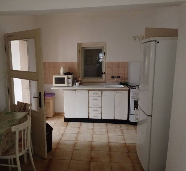 A kitchen in a family house with white cabinets, a microwave, and a refrigerator.