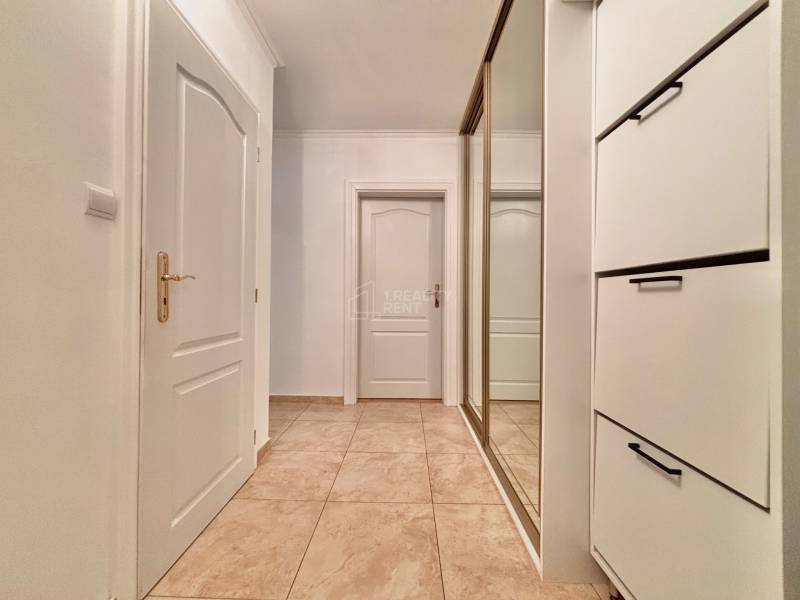 A hallway in a 2-room apartment with white doors and a mirrored wardrobe.