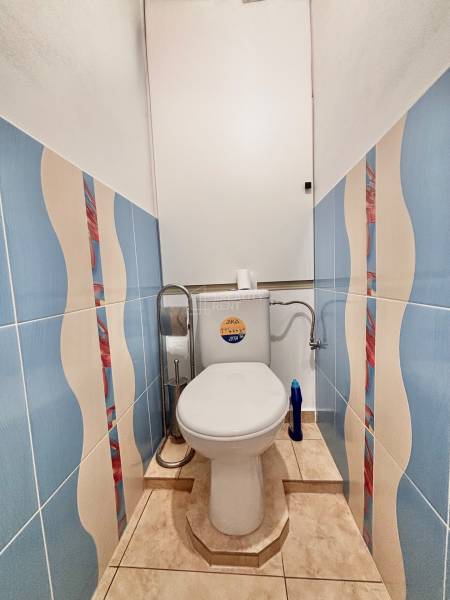 Colorful tiles and a toilet in a 2-room apartment with bold geometric patterns.