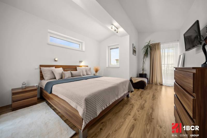 Bedroom in a family house with a bed, decorative elements, and a floor with a wood design.