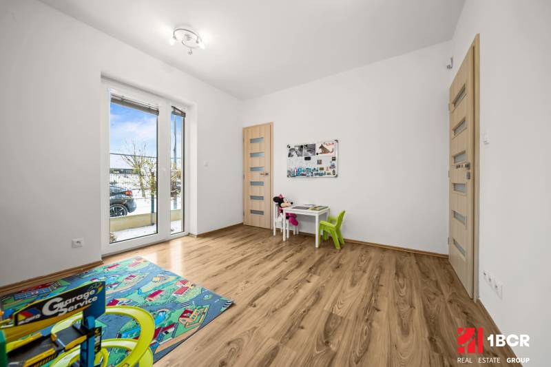 Children's room in a family house with a wooden decor floor and toys.