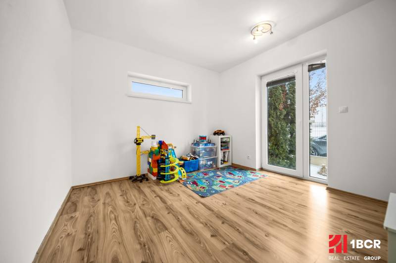 Children's room with toys and a wooden-decor floor in a family house.