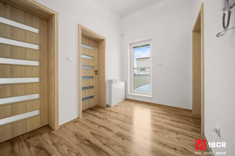 Interior of a family house with a wooden decor floor and doors with glazing.