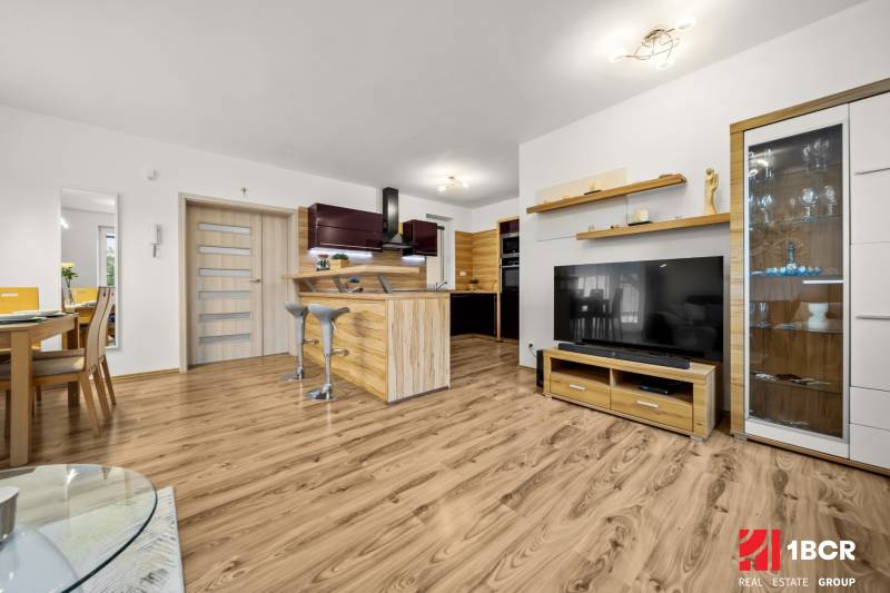 Living room in a family house with a kitchen and a wooden decor floor.