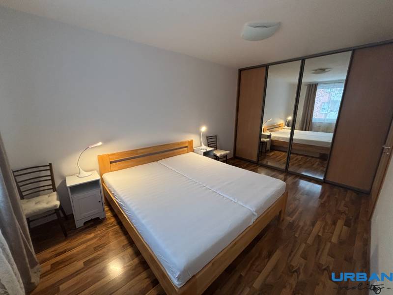 Bedroom with a bed, wardrobe with sliding doors, and floor with wood decor.