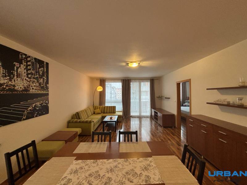 Living room with wood-patterned flooring, a sofa, and a dining table in a 2-room apartment.
