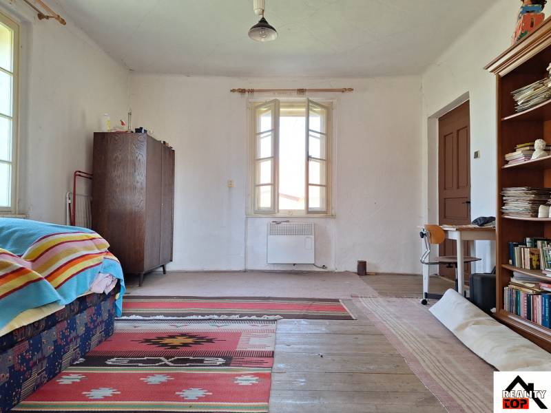 A room in a family house with carpets and a bookshelf, floor with wooden decor.
