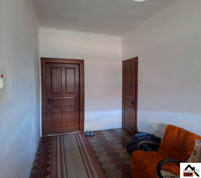 Interior of a family house with doors, an armchair, and a carpet runner.