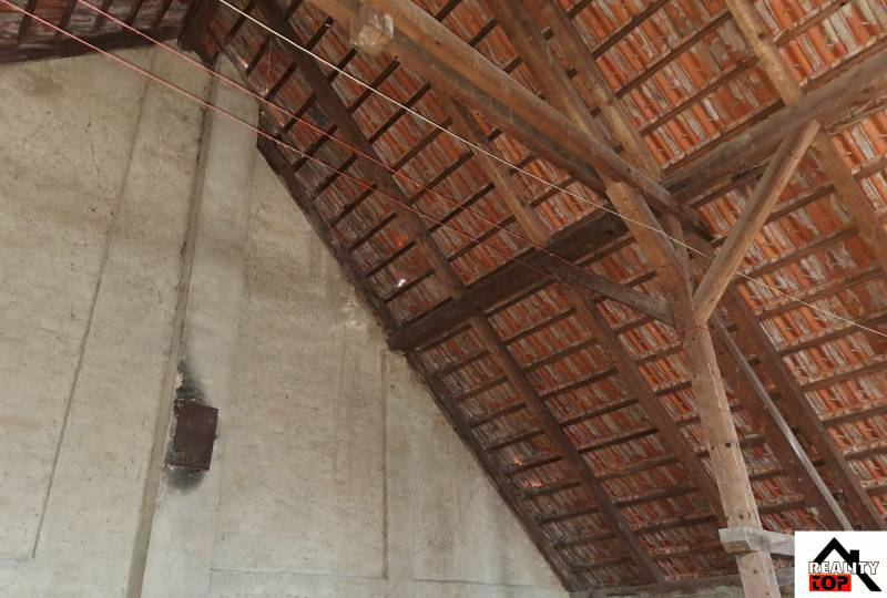 The attic of a family house with wooden beams and ceramic roof tiles in Orávka.