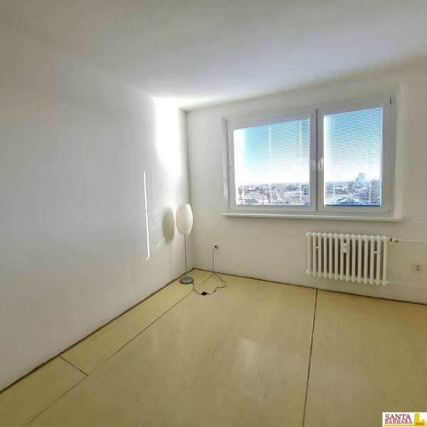 A bright room with wood-decor flooring in a 4-room apartment.