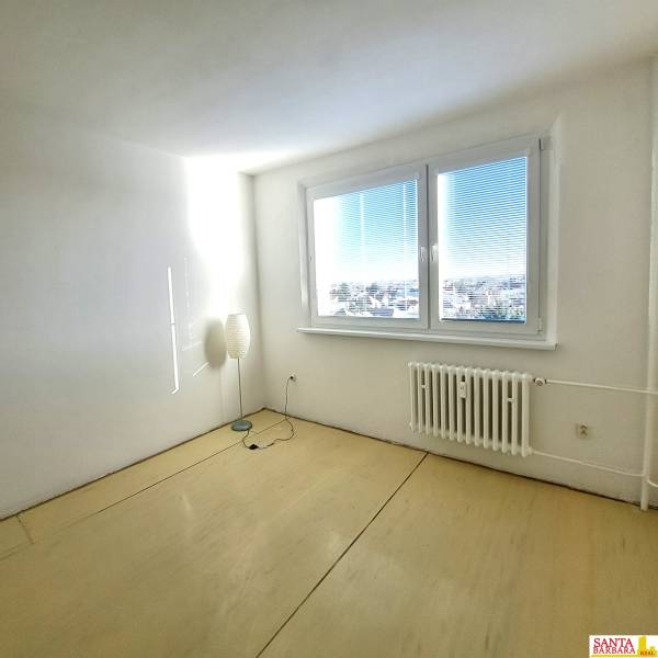 A bright room in a 4-room apartment with a wood-patterned floor and a large window.