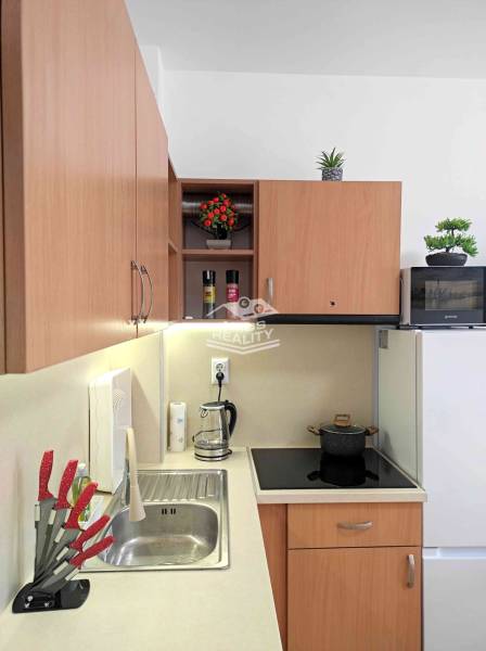 A kitchen in a holiday apartment with wooden decor, appliances, and decorations.