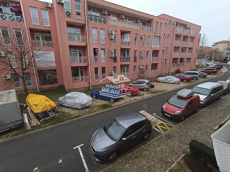 Recreational apartment in Burgas with parked cars in front of a pink building.