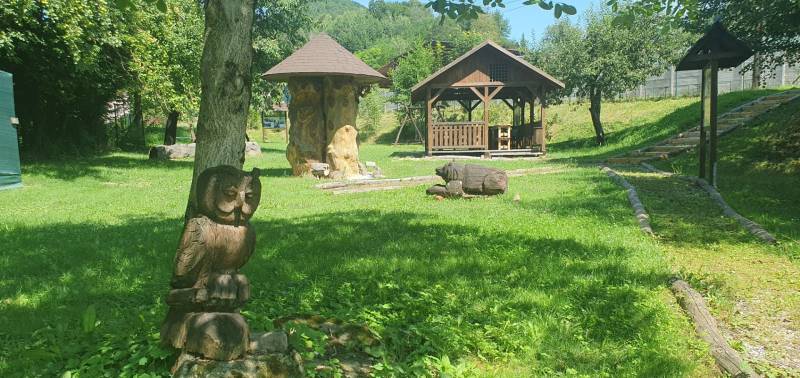 The garden on Hviezdoslavova Street in Tisovec with wooden sculptures near the cottage.