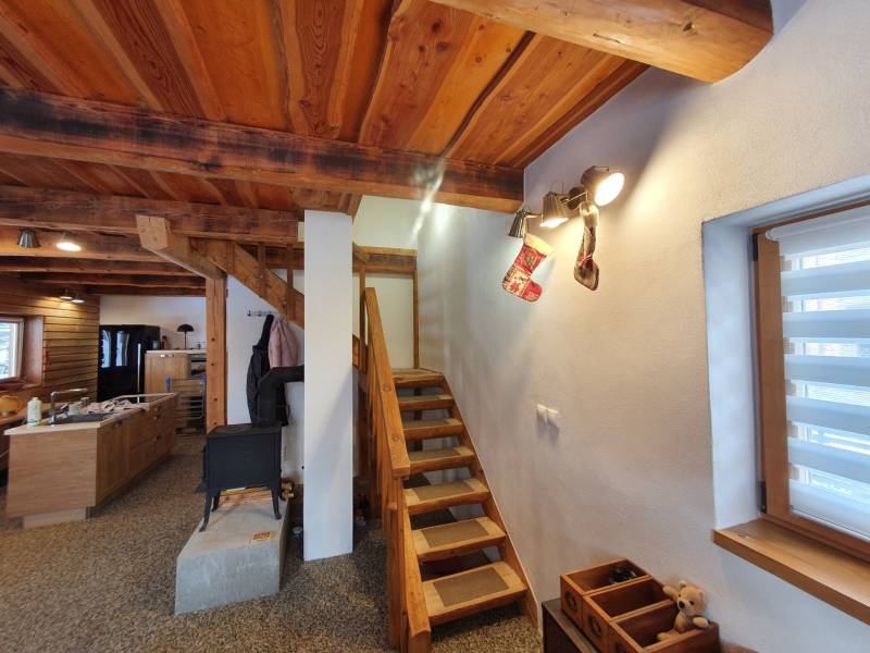 Wooden stairs in a cabin with a wood-decor floor, with Christmas decorations.